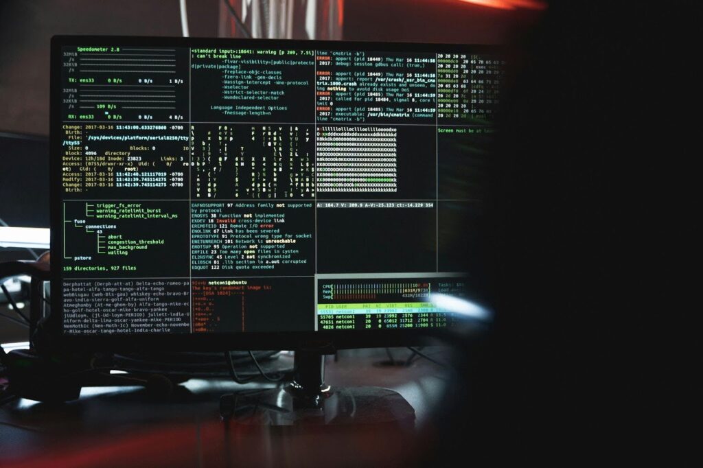 Over-the-shoulder shot of someone looking at a computer monitor displaying multiple screens of code.